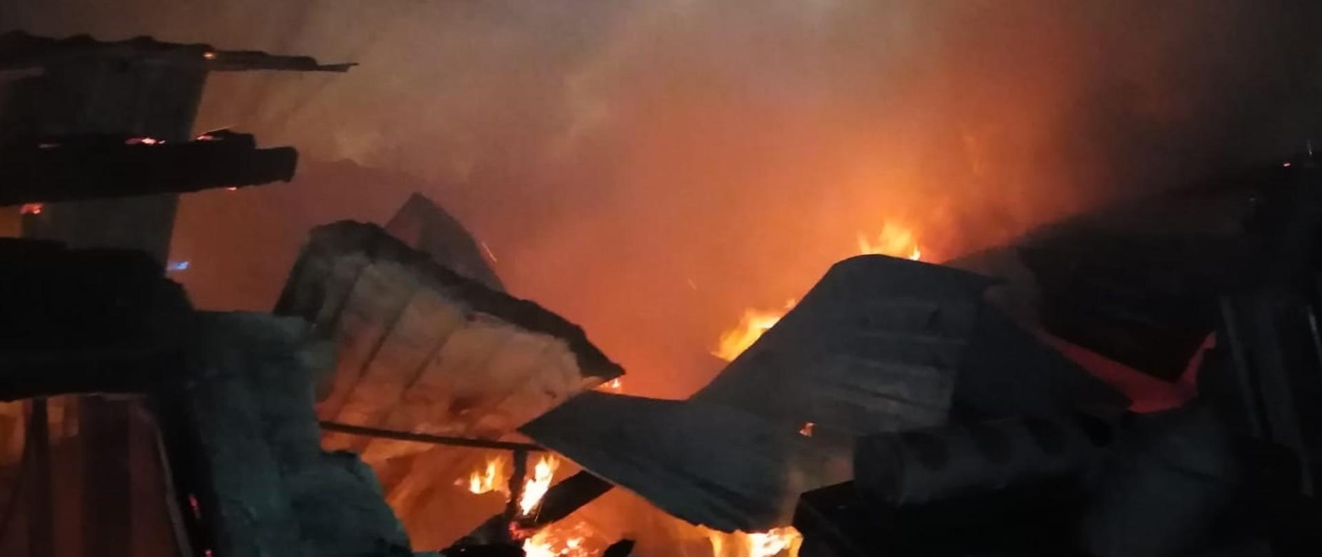 Pora nocna palące się pozostałości stolarni.