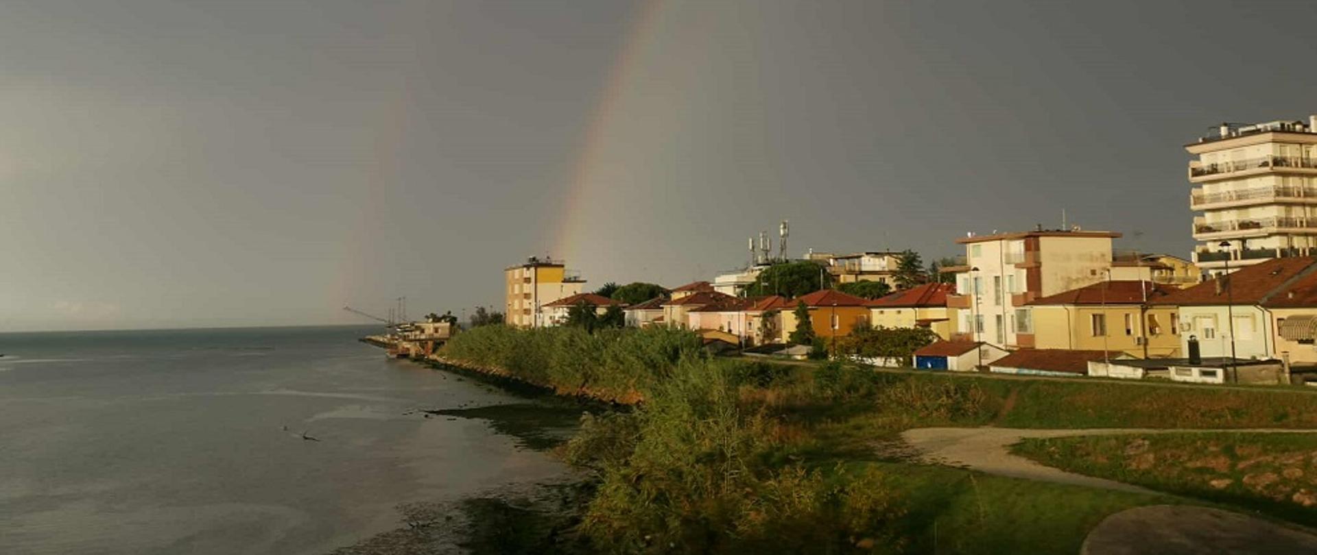Na zdjęciu zatoka po burzy. W tle tęcza. W prawej stronie domy.