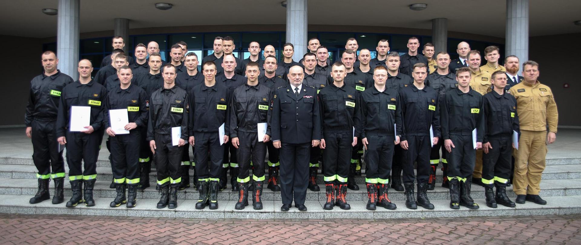 Pamiątkowe zdjęcie grupowe funkcjonariuszy kończących szkolenie podstawowe w zawodzie strażaka (37 osób w tym jedna kobieta) w towarzystwie Komendanta Centralnej Szkoły PSP oraz sześciu funkcjonariuszy CS PSP