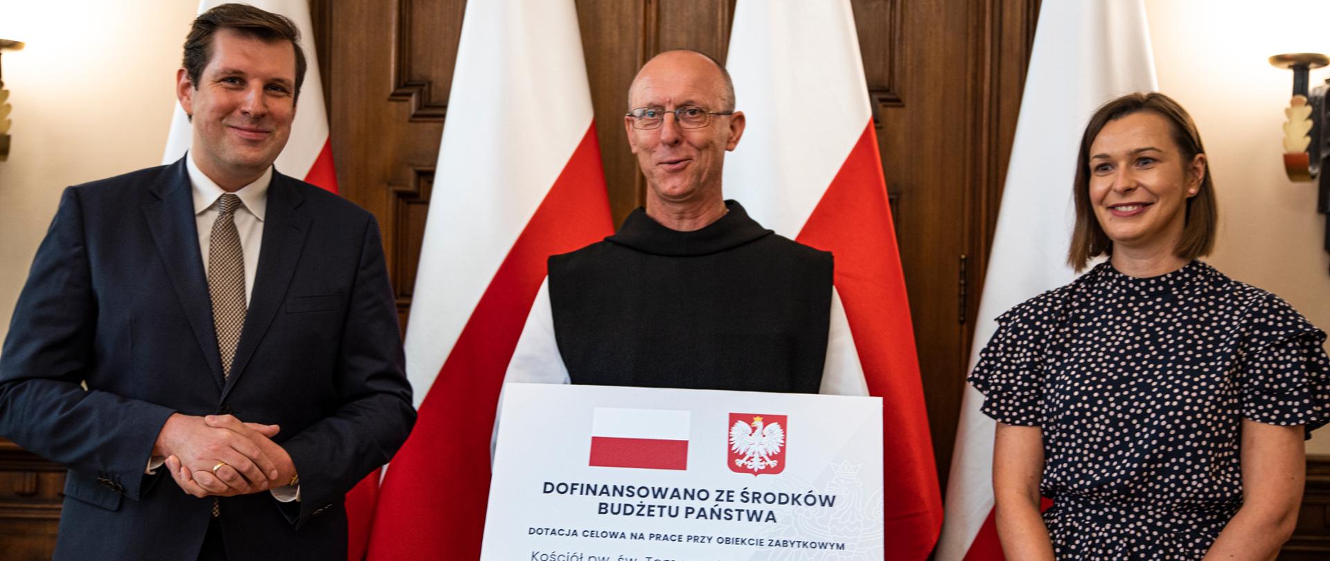 Wojewoda łódzki Tobiasz Bocheński wraz z wojewódzkim konserwatorem zabytków Aleksandrą Stępień wręczają czek dla kościoła w Sulejowie