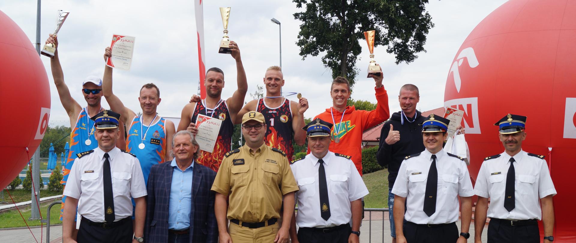 Zdjęcie przedstawia zwycięskie drużyny wraz z organizatorami mistrzostw.
