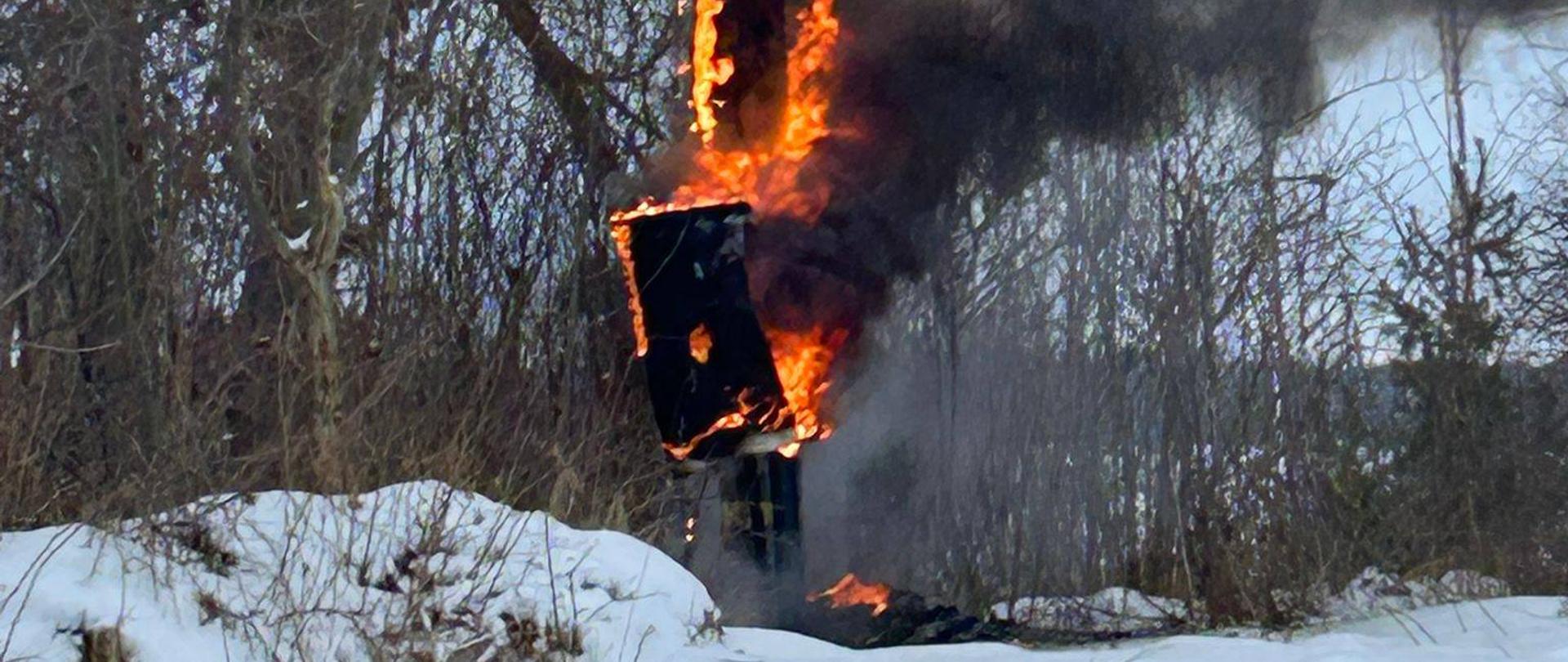 Pożar stacji transformatorowej. Słup elektryczny w ogniu unosi się czarny dym.