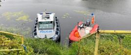 Dwie motorówki stoją puste przy brzegu rzeki