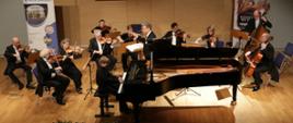 Zdjęcie Orkiestry Kameralnej Filharmonii Narodowej podczas koncertu na scenie wraz z pianistą (przy fortepianie Mateusz Łuczak fot. Starostwo Powiatowe w Jarosławiu
