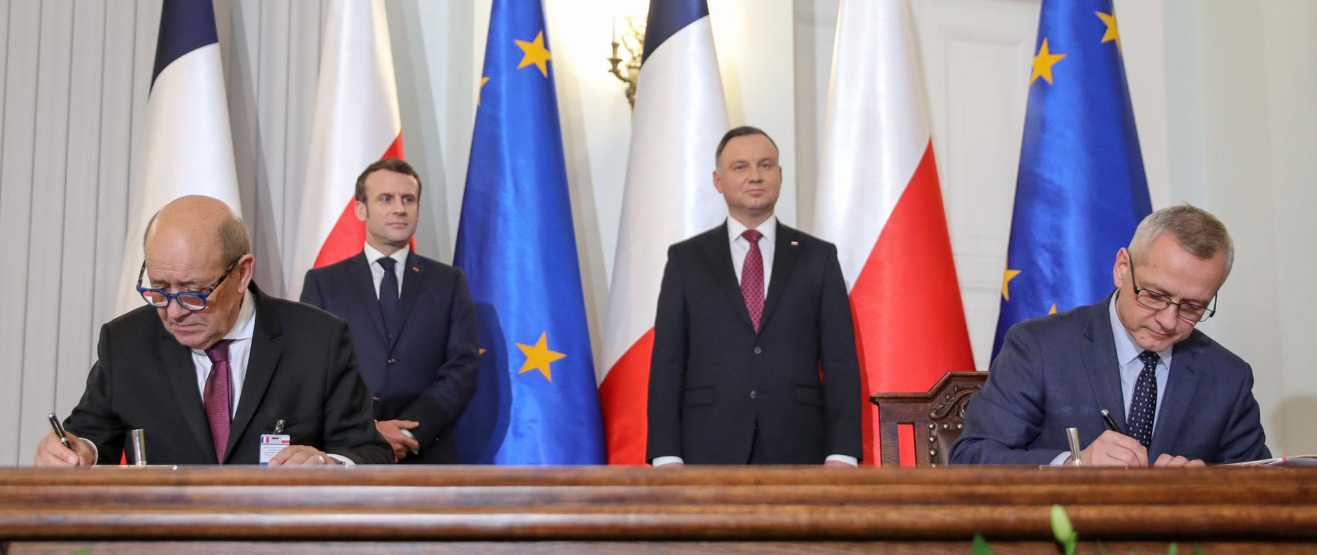 Moment podpisania deklaracji - przy stole (po lewej) minister Minister Europy i Spraw Zagranicznych Francji Jean-Yves Le Drian, (po prawej) Minister cyfryzacji RP Marek Zagórski. Za nimi stoją: (po lewej ) Prezydent Francji Emmanuel Macron, (po prawej) Prezydent RP Andrzej Duda