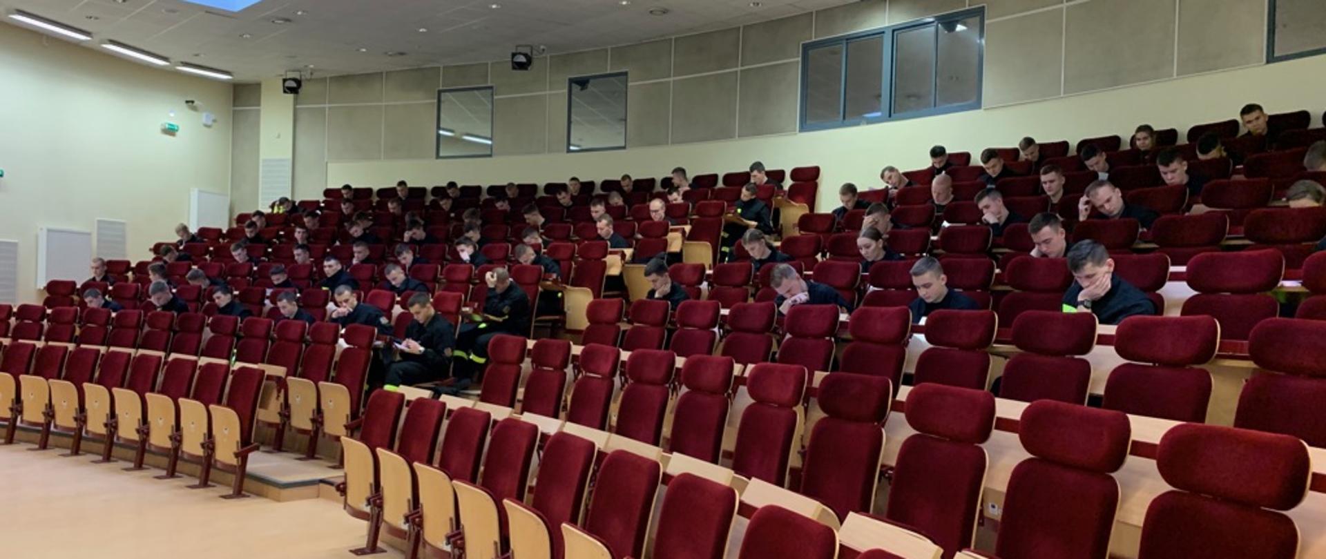 Zdjęcie przedstawia studentów SGSP na auli podczas egzaminu z ratownictwa medycznego.