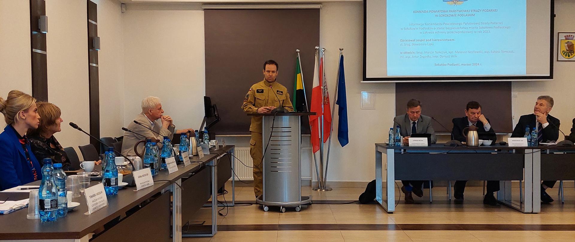 Przedstawienie informacji Komendanta Powiatowego Państwowej Straży Pożarnej w Sokołowie Podlaskim dot.: bezpieczeństwa przeciwpożarowego w Sokołowie Podlaskim w roku 2023 - na zdjęciu komendant przedstawia temat