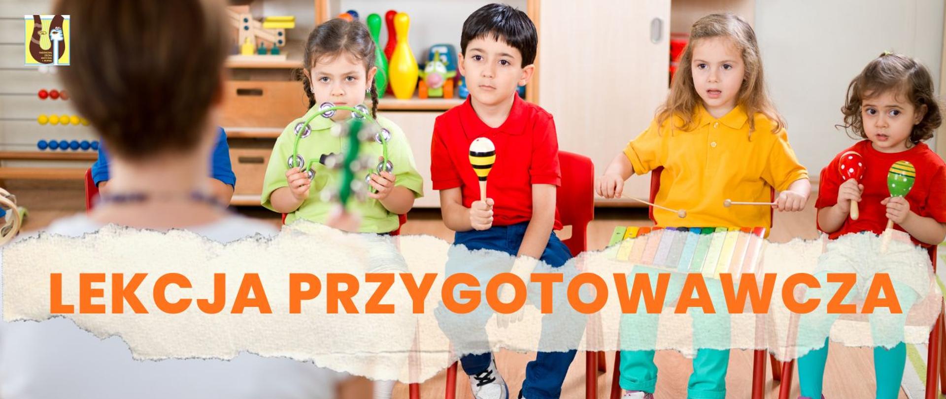 czworo dzieci grających na instrumentach perkusyjnych, na pierwszym planie nauczycielka, w prawym górnym rogu znajduje się logo szkoły muzycznej, napis "Lekcja przygotowawcza" w kolorze pomarańczowym