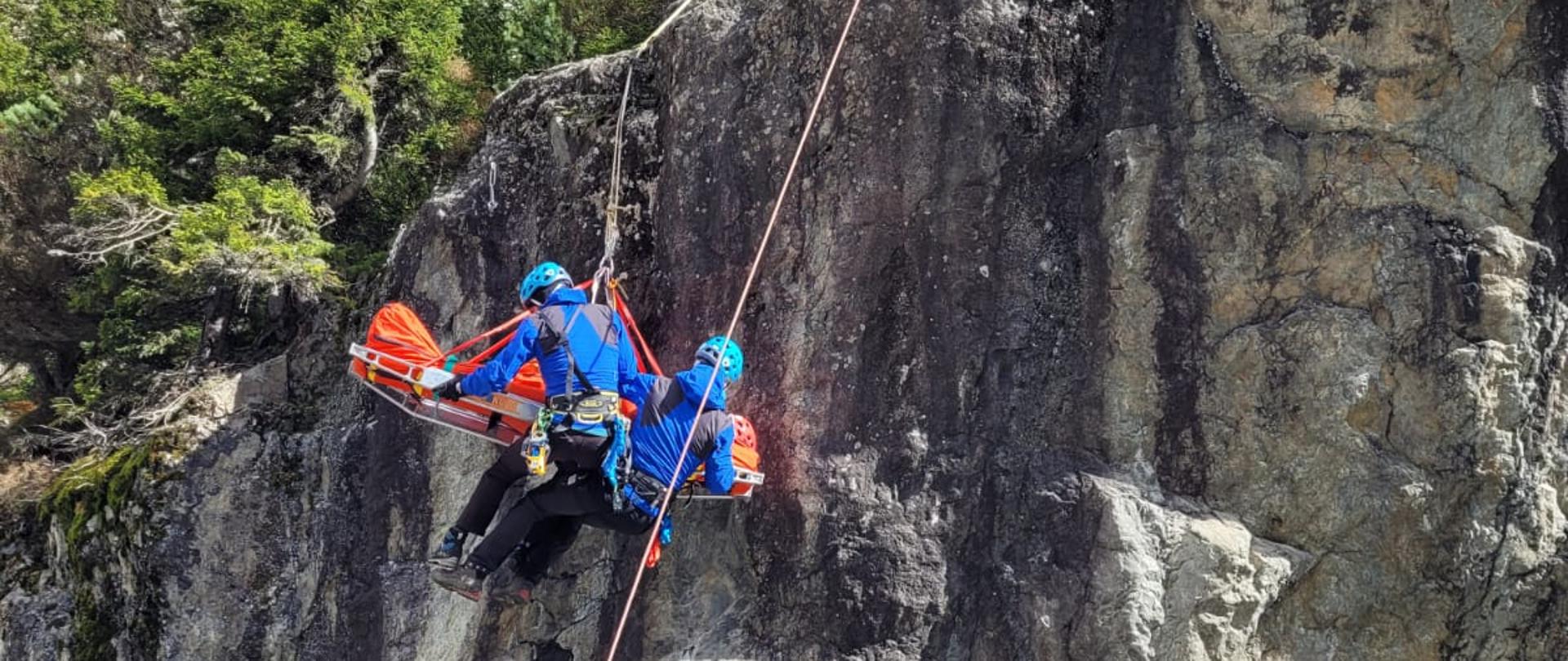Transportowanie rannego ze zbocza góry