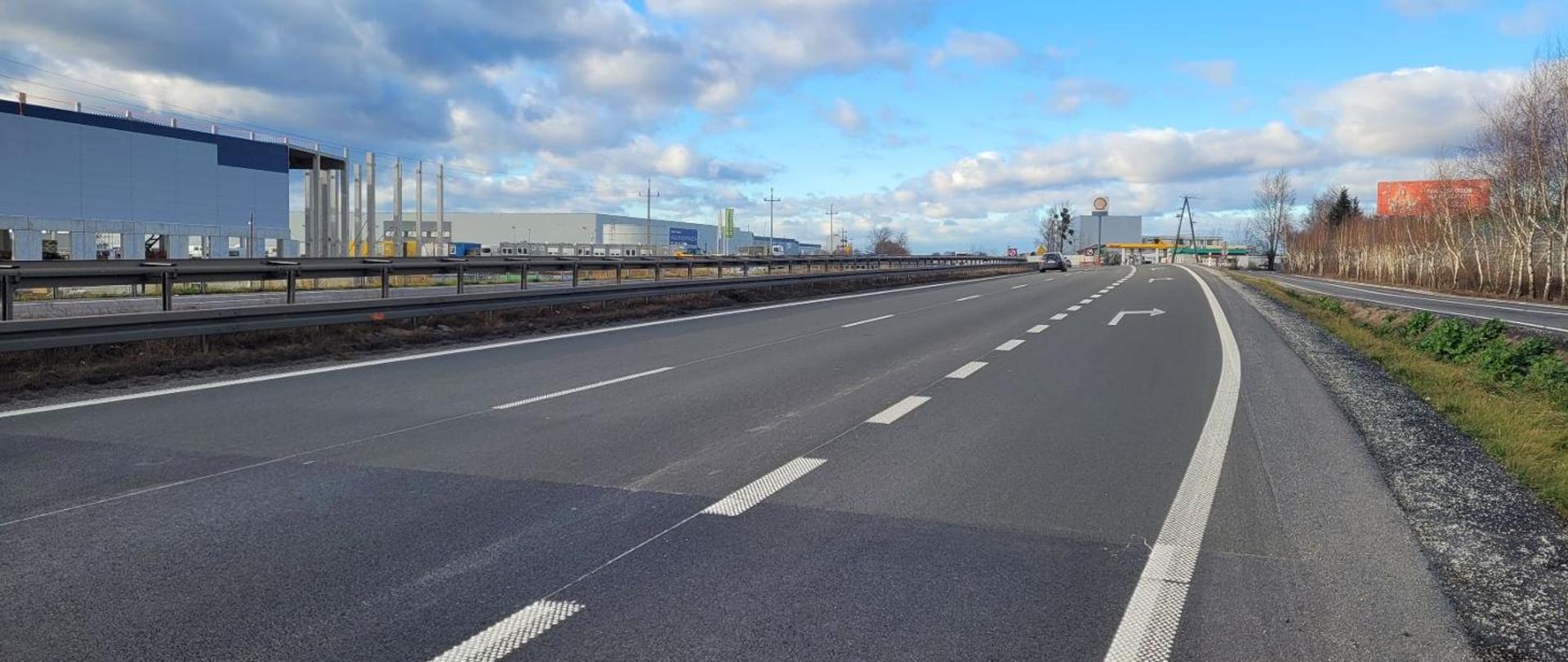 Droga ekspresowa dwujezdniowa, w tle zabudowania przemysłowe