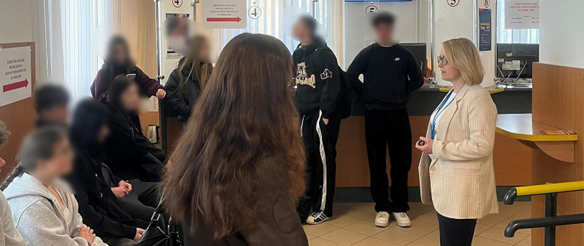 Sala obsługi w urzędzie skarbowym. Pracownik urzędu i młodzież 