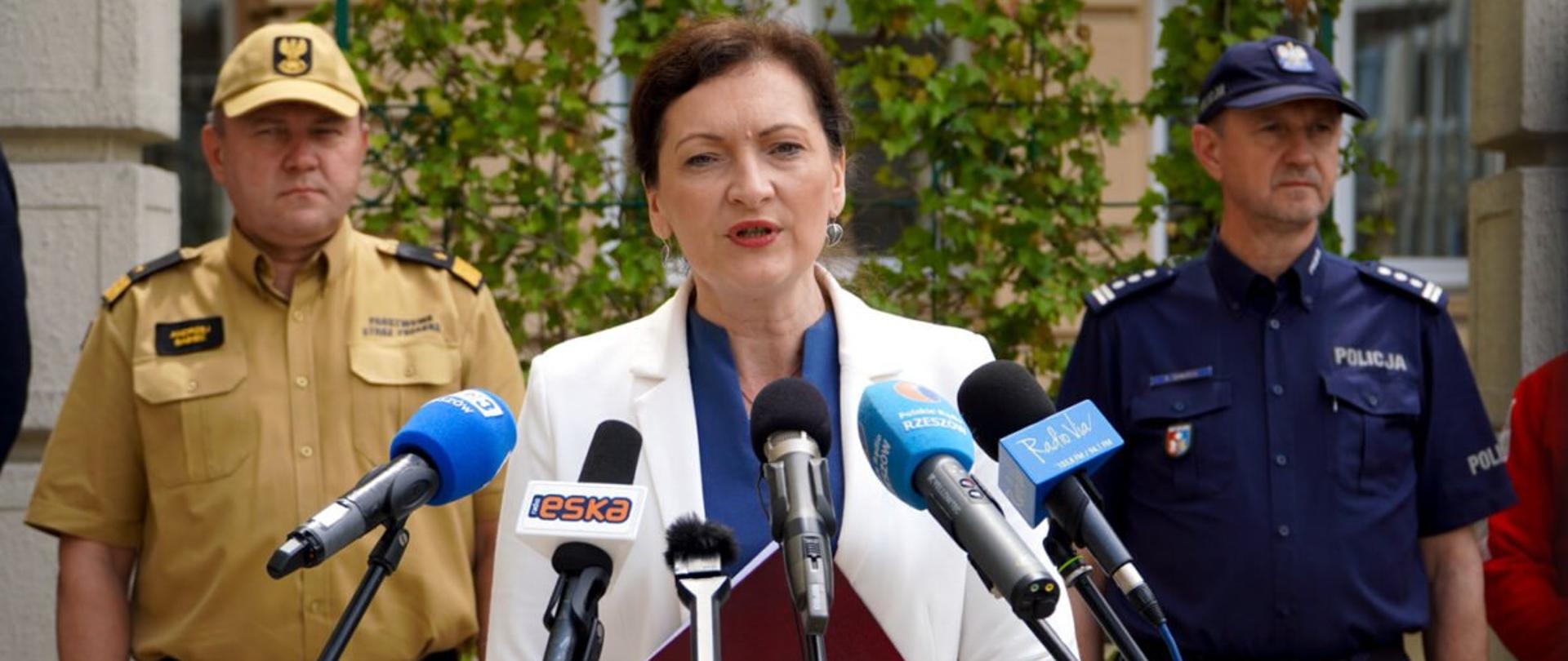 Wojewoda podkarpacki Ewa Leniart zabiera głos podczas konferencji prasowej.Za wojewodą komendant wojewódzki Państwowej Straży Pożarnej oraz zastępca komendanta wojewódzkiego Policji