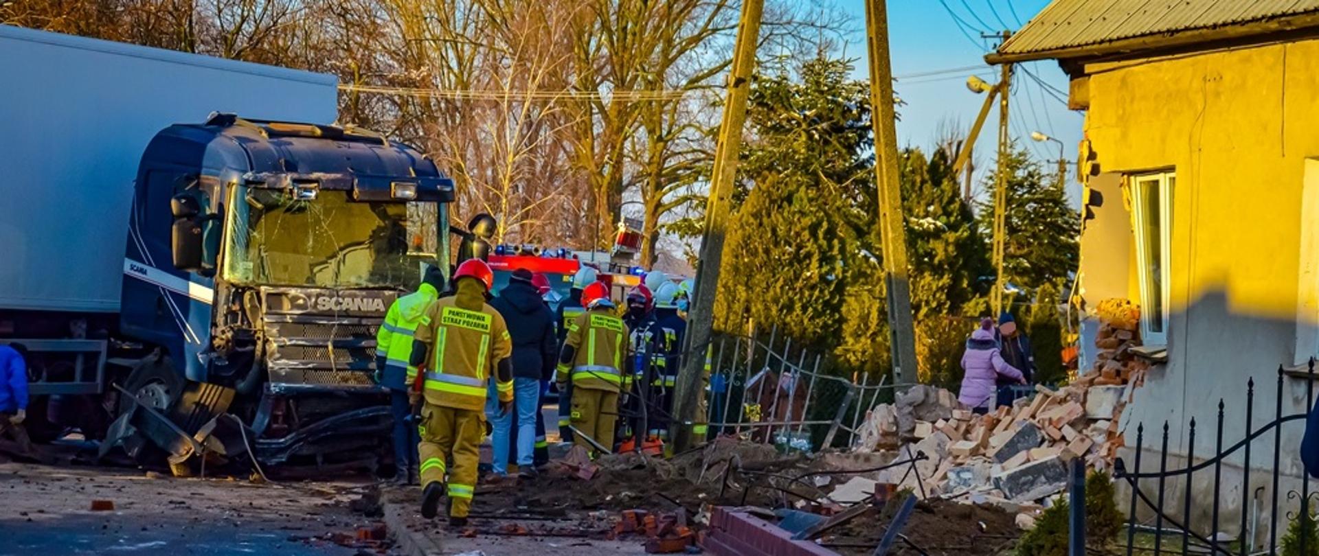 Działania ratownicze strażaków po uderzeniu ciężarówki w budynek mieszkalny