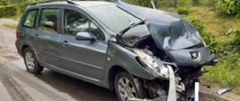 Na zdjęciu widoczny rozbity samochód Peugeot Combi. Uszkodzony przód pojazdu wskazujący na zderzenie czołowe.
