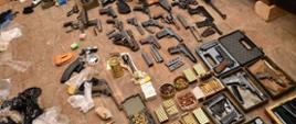 Wykryta broń i amunicja ułożone na ziemi.