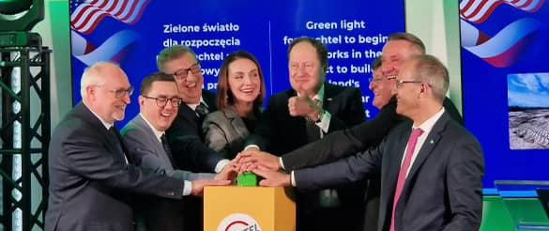 Sala, w niej kilka osób naciska przycisk, symbolicznie rozpoczynając inwestycję w gminie Choczewo (elektrownia jądrowa)