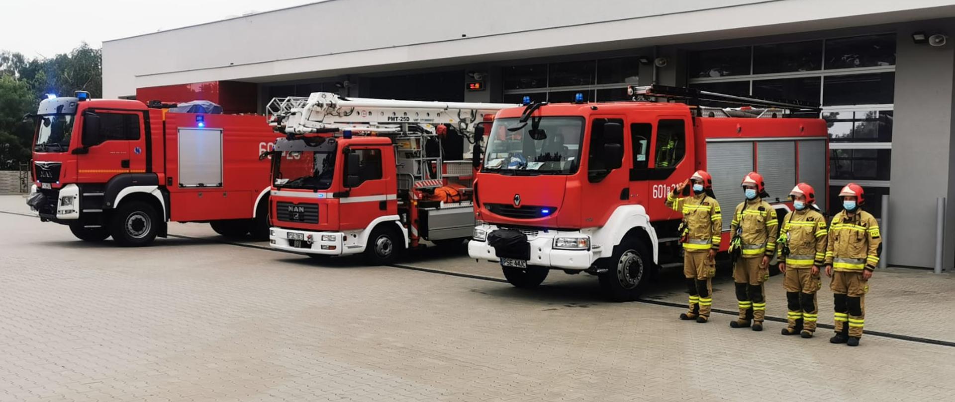 Na zdjęciu strażacy oraz pojazdy pożarnicze z sygnałami świetlnymi i dźwiękowymi podczas zbiórki i oddania hołdu bohaterom Powstania Warszawskiego. Pojazdy wystawione przed bramy garażowe Komendy Powiatowej PSP w Śremie