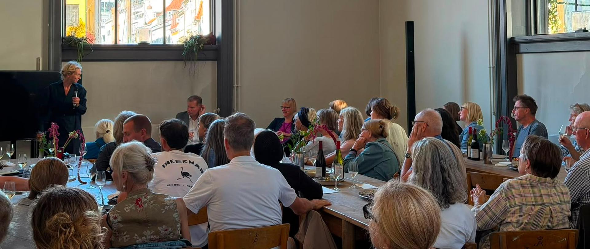 Panel dyskusyjny z udziałem trzech osób rozmawiających przed publicznością podczas wydarzenia w Kunsthal Charlottenborg.