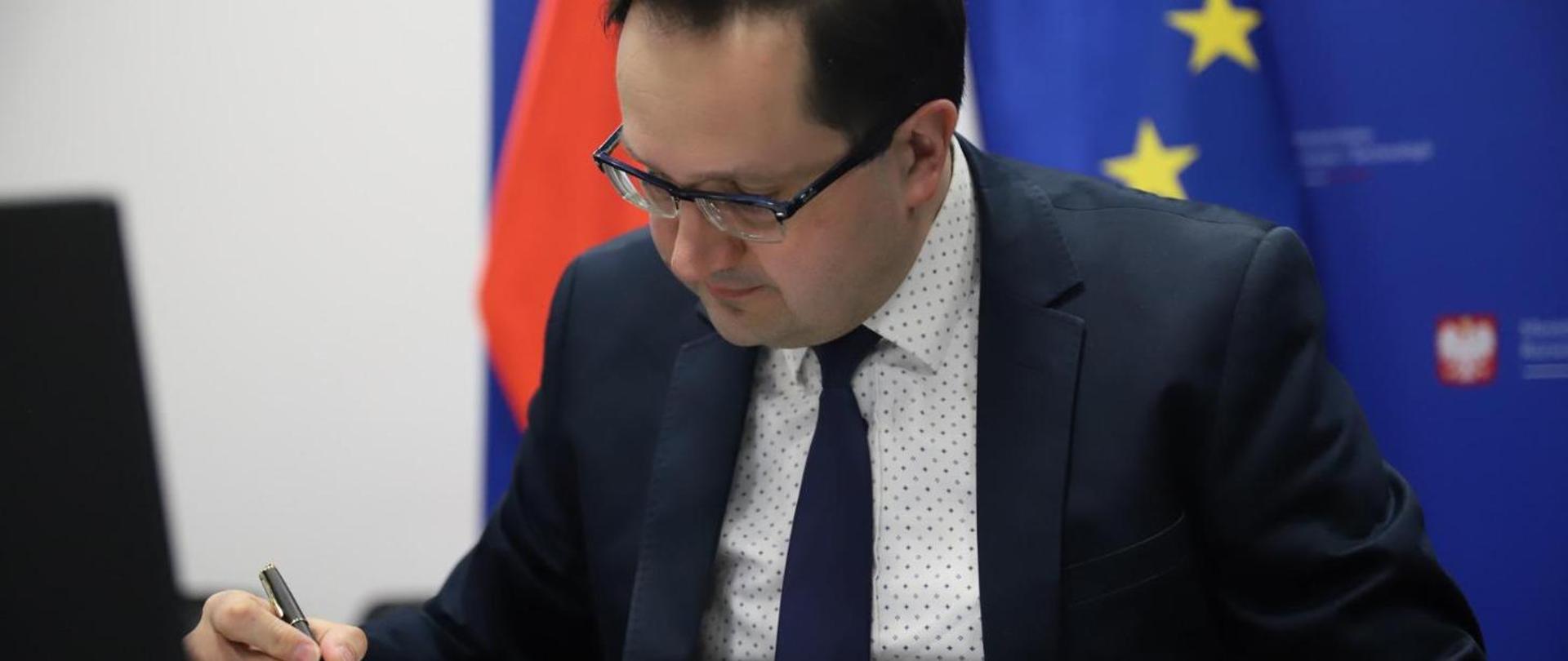 Deputy minister Jerzy Golecki signing a docyment
