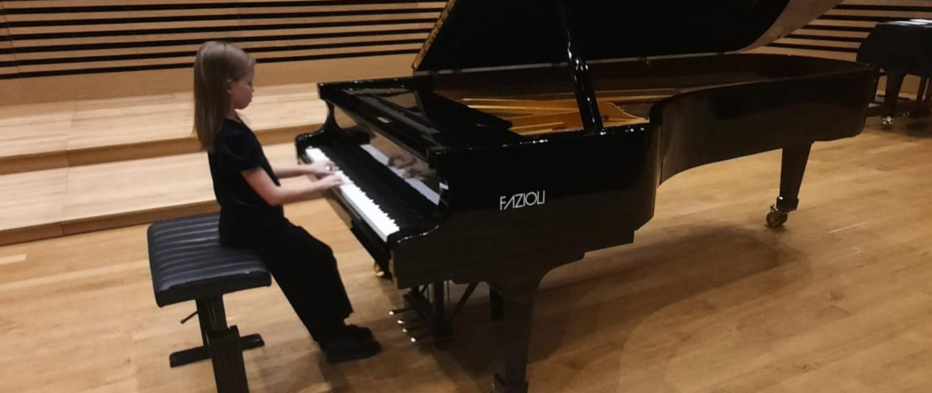 Dziewczynka gra na fortepianie Fazioli w sali koncertowej