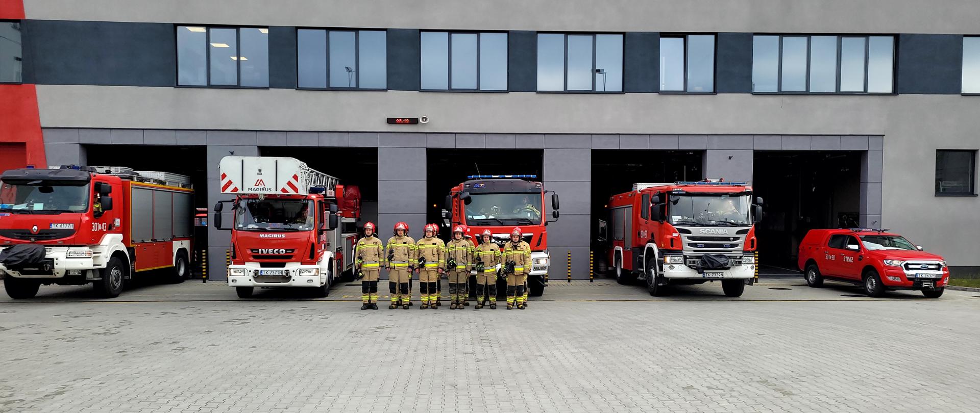 Fotografia przedstawia strażaków oraz pojazdy z Jednostki Ratowniczo-Gaśniczej nr 1 w Kielcach podczas załączenia syren ku uczczeniu pamięci tych, którzy zginęli w katastrofie smoleńskiej 12 lat temu.