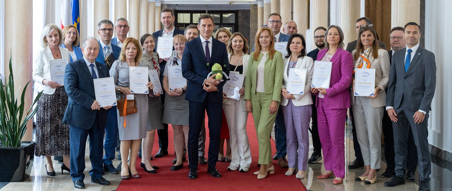 Osoby z dyplomami na korytarzu w Ministerstwie Finansów