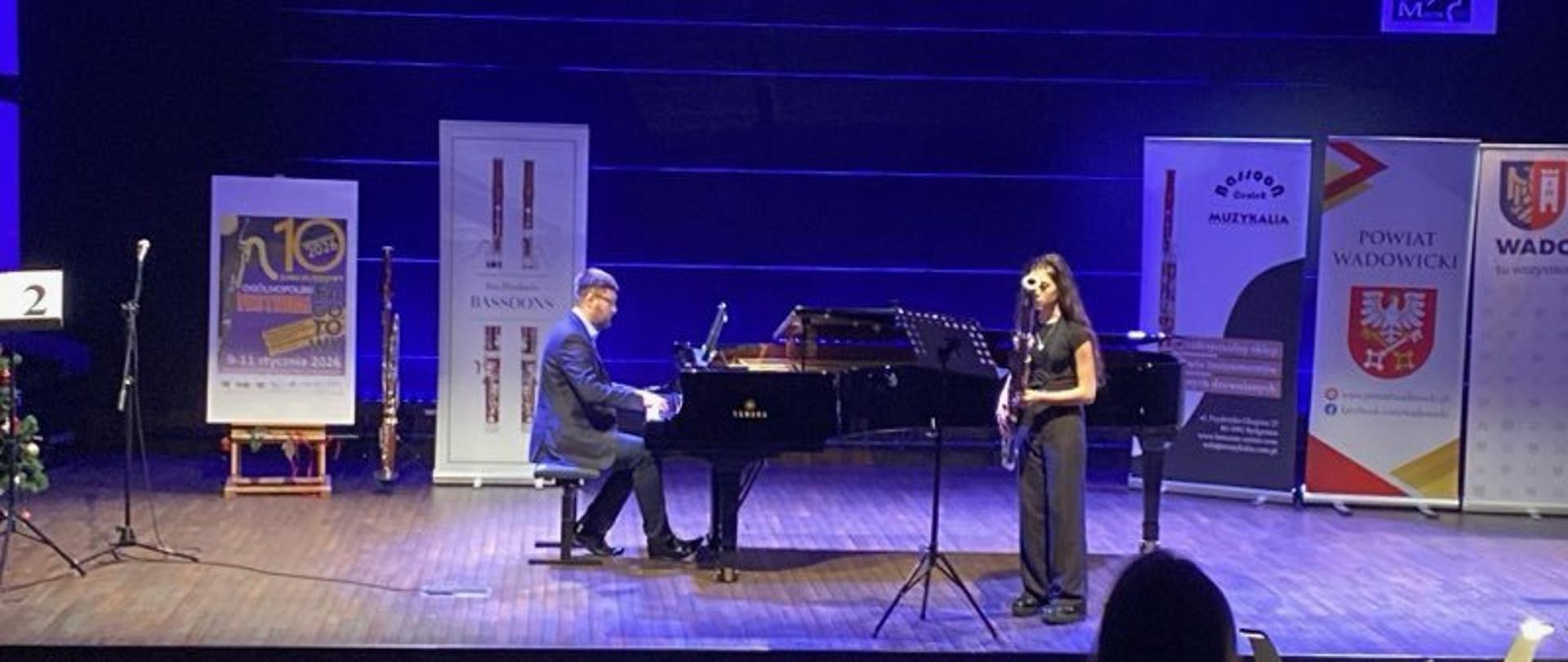 Uczennica gra na fagocie na scenie podczas festiwalu w Wadowicach, z akompaniamentem pianisty przy fortepianie.