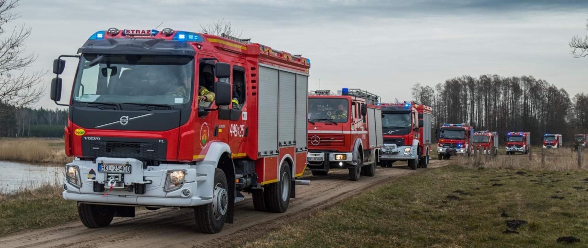 Na zdjęciu widać kolumnę samochodów pożarniczych jadących na ćwiczenia