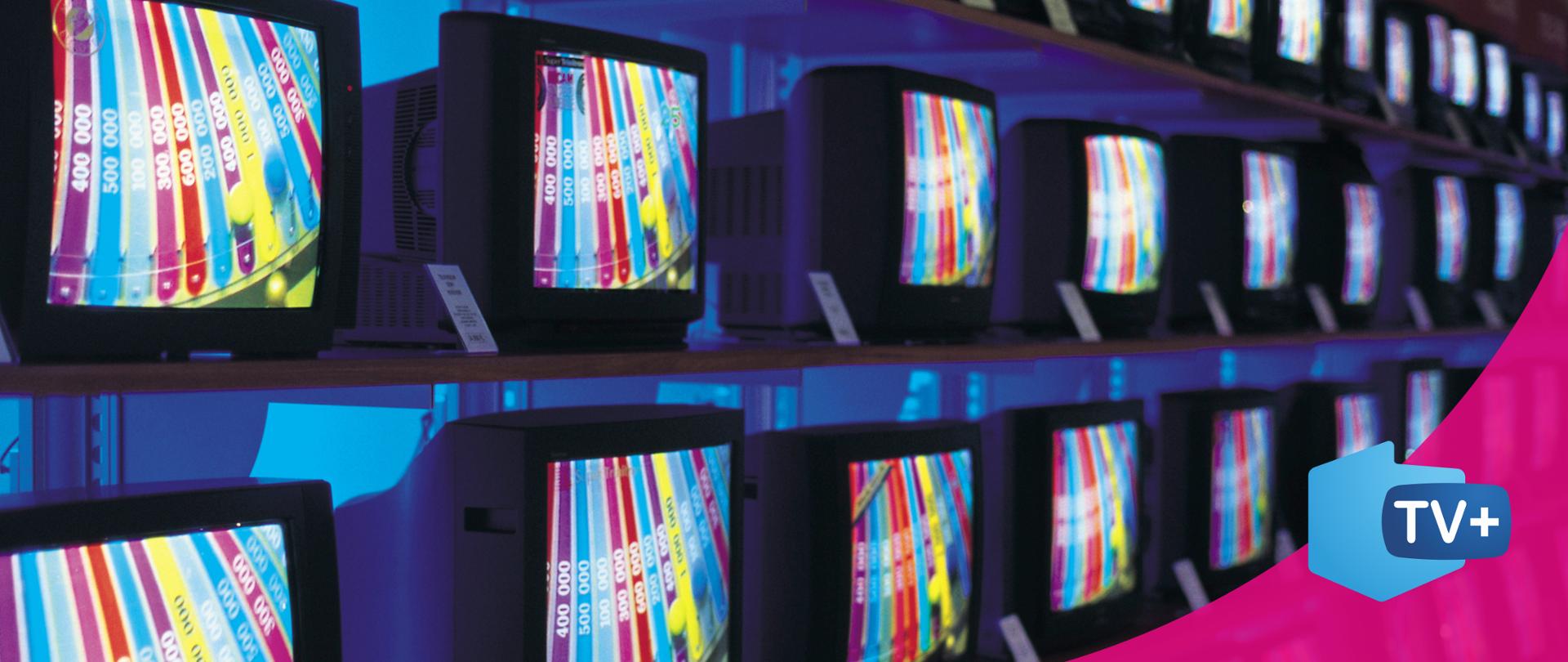 Na ekranie, widzimy w szeregu ustawione telewizory. 