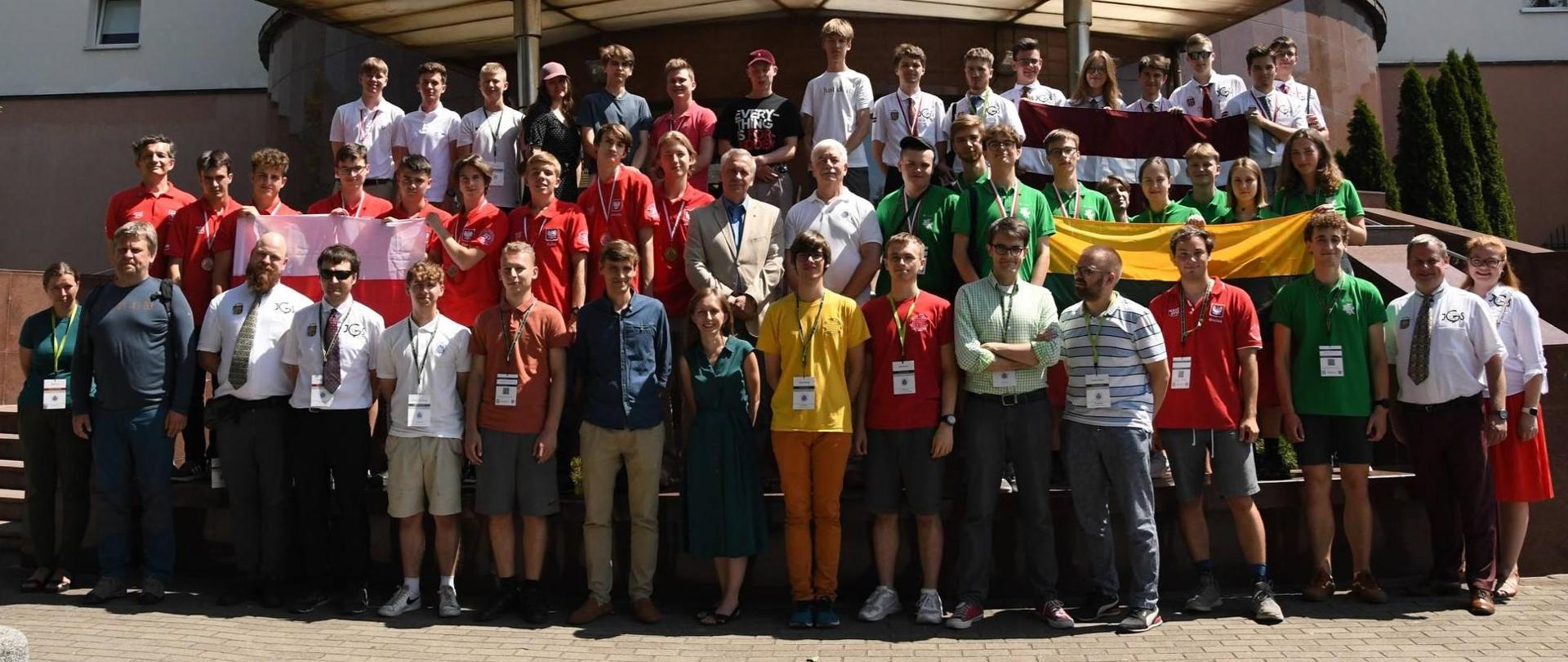 Zdjęcie zbiorowe, przed budynkiem na schodach stoi duża grupa ludzi.