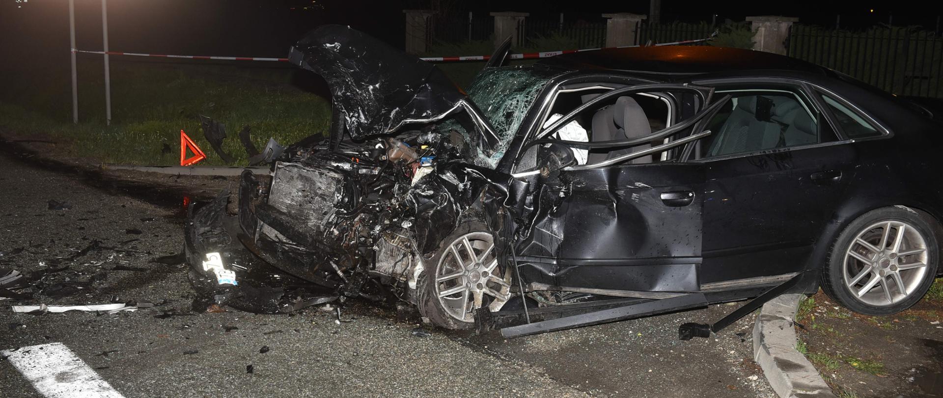 Zdjęcie przedstawia uszkodzony samochód na pasie drogi