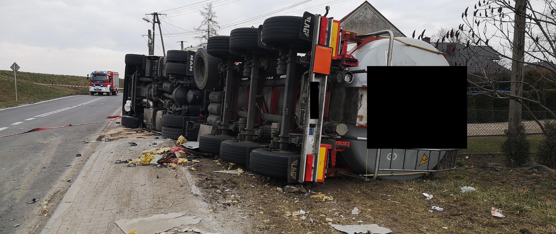 zdjęcie przedstawia leżącą cysternę oraz wóz strażacki