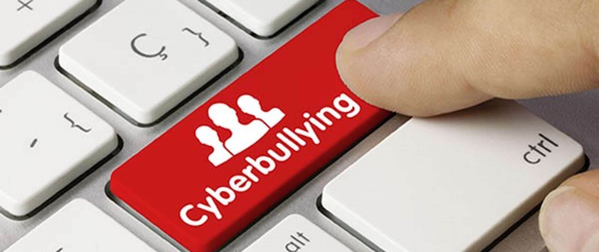 Klawiatur komputera z czerwonym klawiszem z napisem Cyberbullying