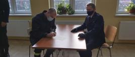 Strażak podpisujący akt ślubowania.
