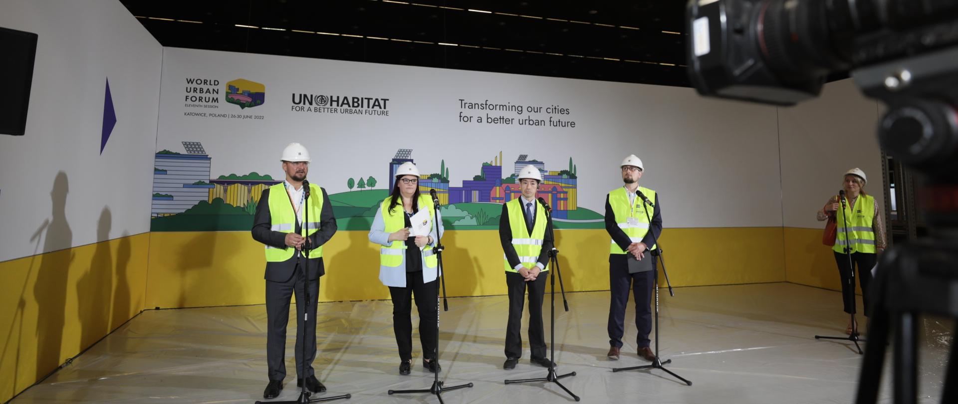 uczestnicy konferencji stoją przy mikrofonach