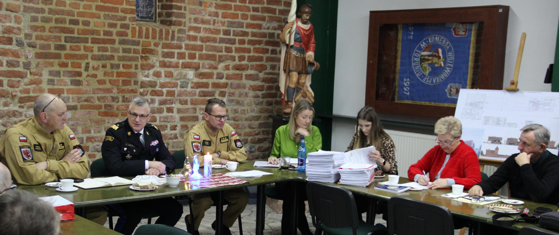 Widok na członków komisji socjalnej podczas obrad. W tle wystój i wyposażenie świetlicy. 