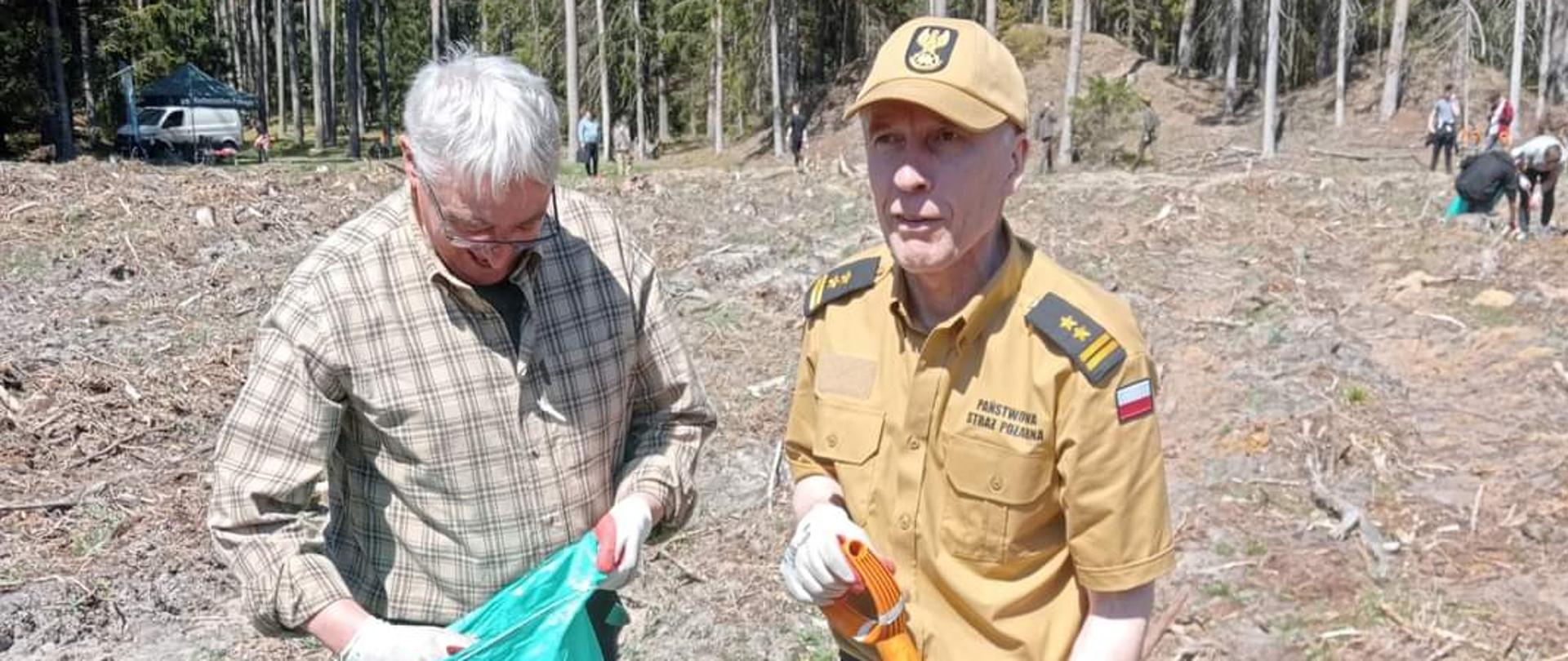 Zdjęcie przedstawia dwie osoby podczas sadzeniu lasu jedną z nich jest Komendant Powiatowy PSP w Świdwinie