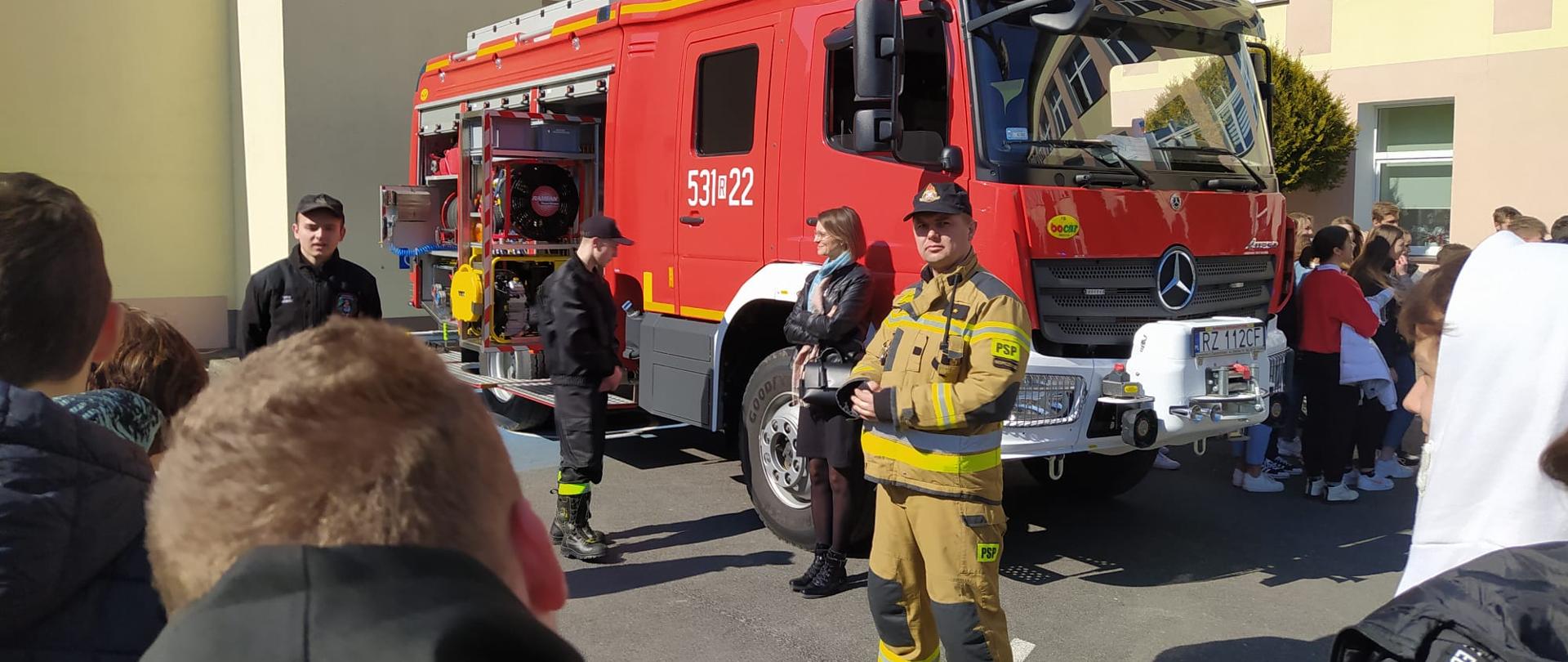 Strażak PSP przedstawia uczniom wyposażenie samochodu pożarniczego