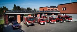 Część pojazdów pożarniczych JRG na tle garaży