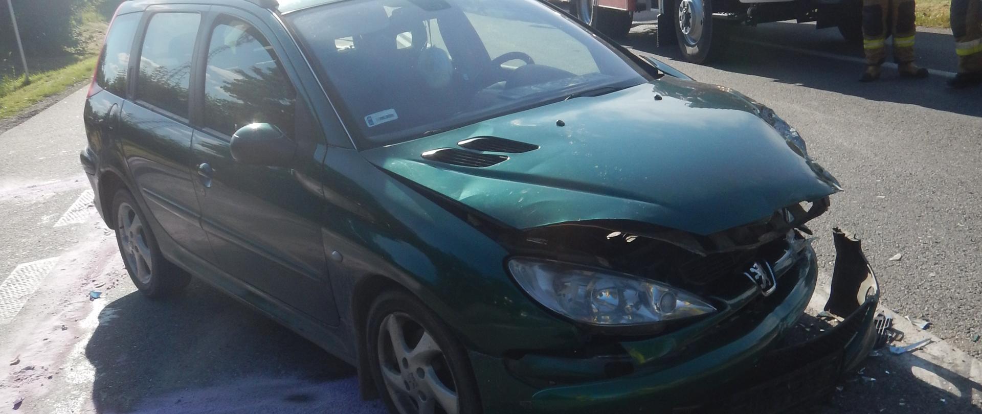 Zdjęcie przedstawia rozbity przód samochodu osobowego marki Peugeot