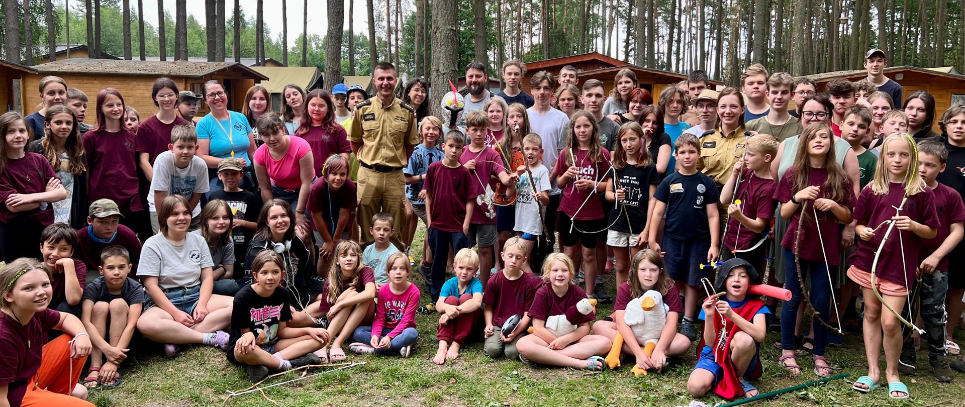 Funkcjonariusze KP PSP w Kwidzynie pozują do zdjęcia z harcerzami.