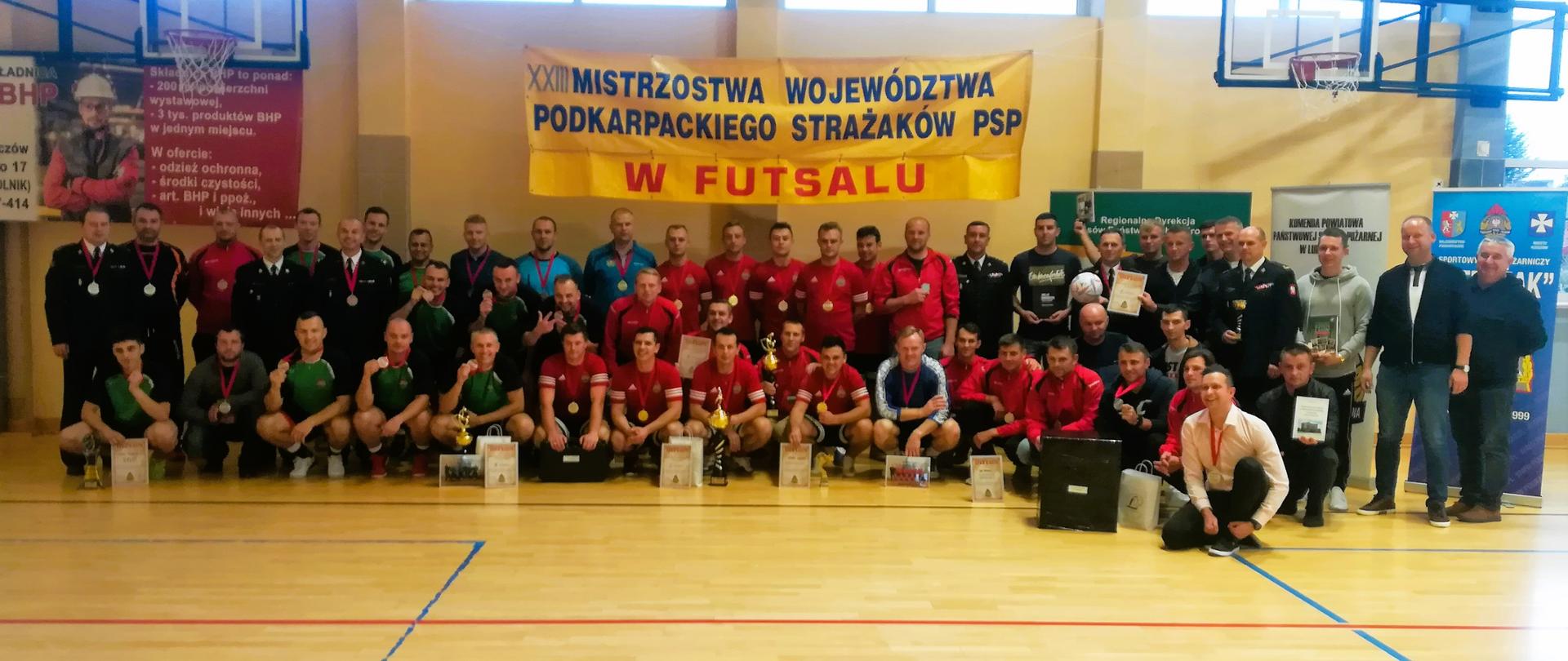Zdjęcie przedstawia wszystkich uczestników oraz zaproszonych gości podczas XXIII Mistrzostwa Województwa Podkarpackiego Strażaków PSP w Futsalu