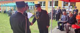 Na zdjęciu uczestnicy obchodów jubileuszu siedemdziesięciopięciolecia Ochotniczej Straży Pożarnej w Morawach oraz zaproszeni goście. Zastępca pomorskiego komendanta wojewódzkiego Państwowej Straży Pożarnej odbiera podziękowanie.