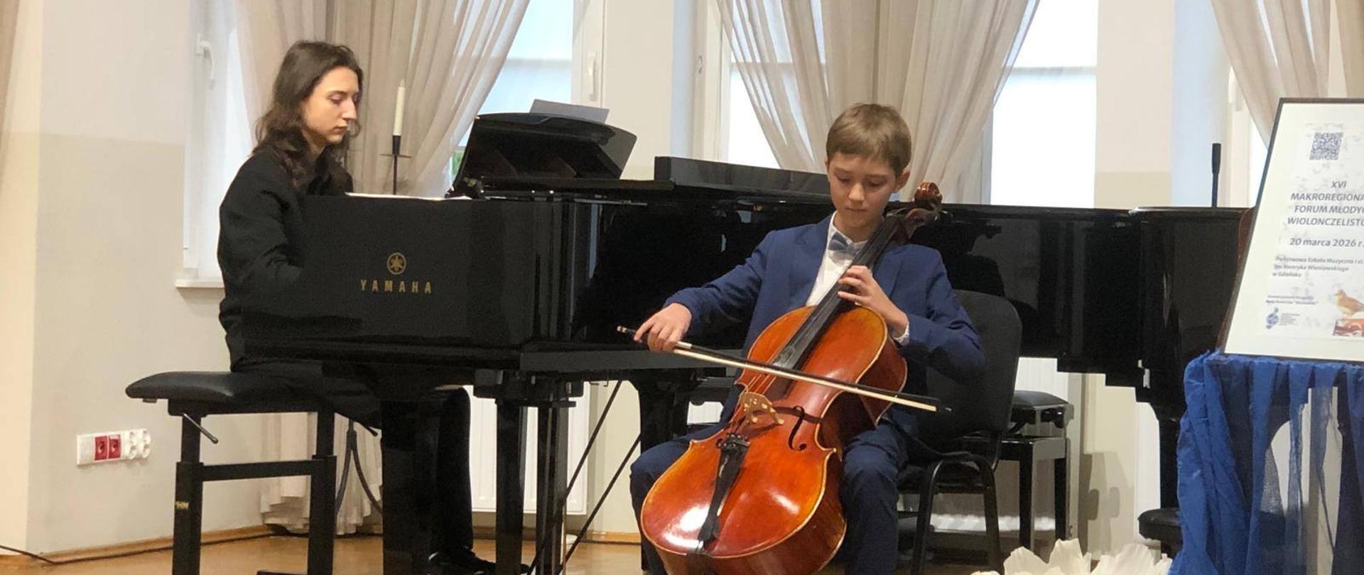 Uczeń gra na wiolonczeli podczas konkursu. W tle akompaniator Ryszard Chwalisz.