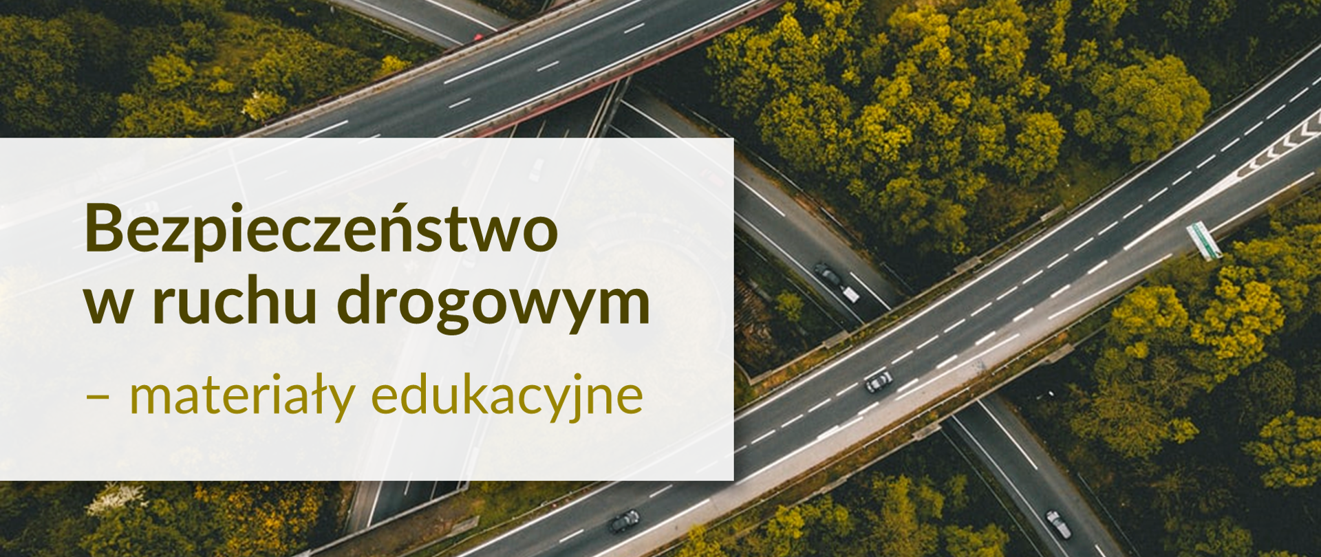 Widok z góry na kilka krzyżujących się dróg, po których jedzie kilka samochodów. Pomiędzy ulicami i wiaduktami rosną drzewa. Po lewej stronie napis Bezpieczeństwo w ruchu drogowym - materiały edukacyjne 