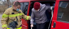 Na zdjęciu strażak pomaga wysiąść z samochodu.