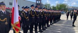 Funkcjonariusze Kompanii Reprezentacyjnej Komendy Wojewódzkiej PSP w Warszawie stoją w dwuszeregu, dowódca składa meldunek 