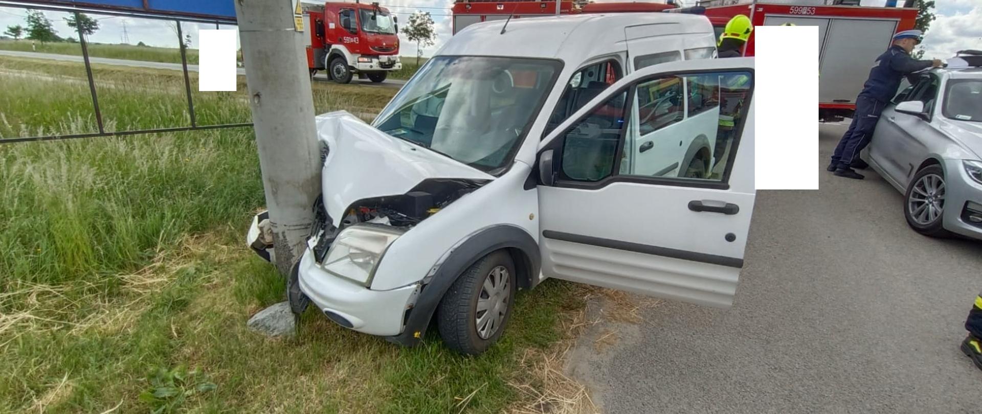Widać uszkodzony biały samochód, który uderzył w słup
