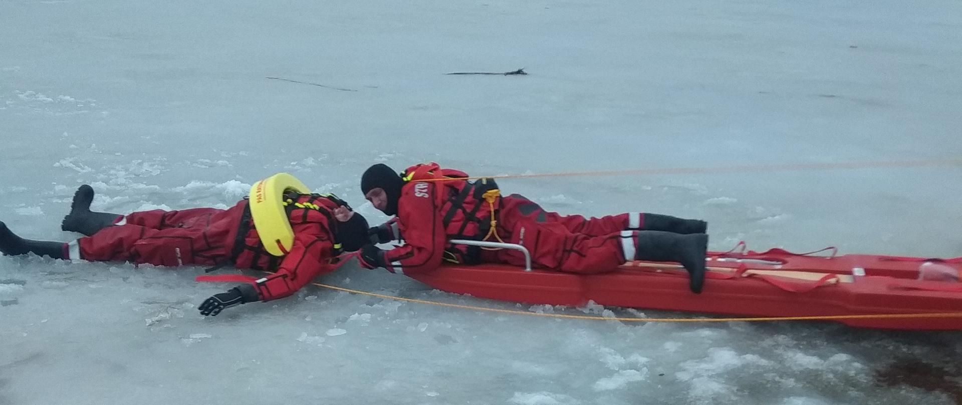 Zdjęcie przedstawia ćwiczenia strażaków JRG i OSP z ratownictwa lodowego na zalewie w Korycinie