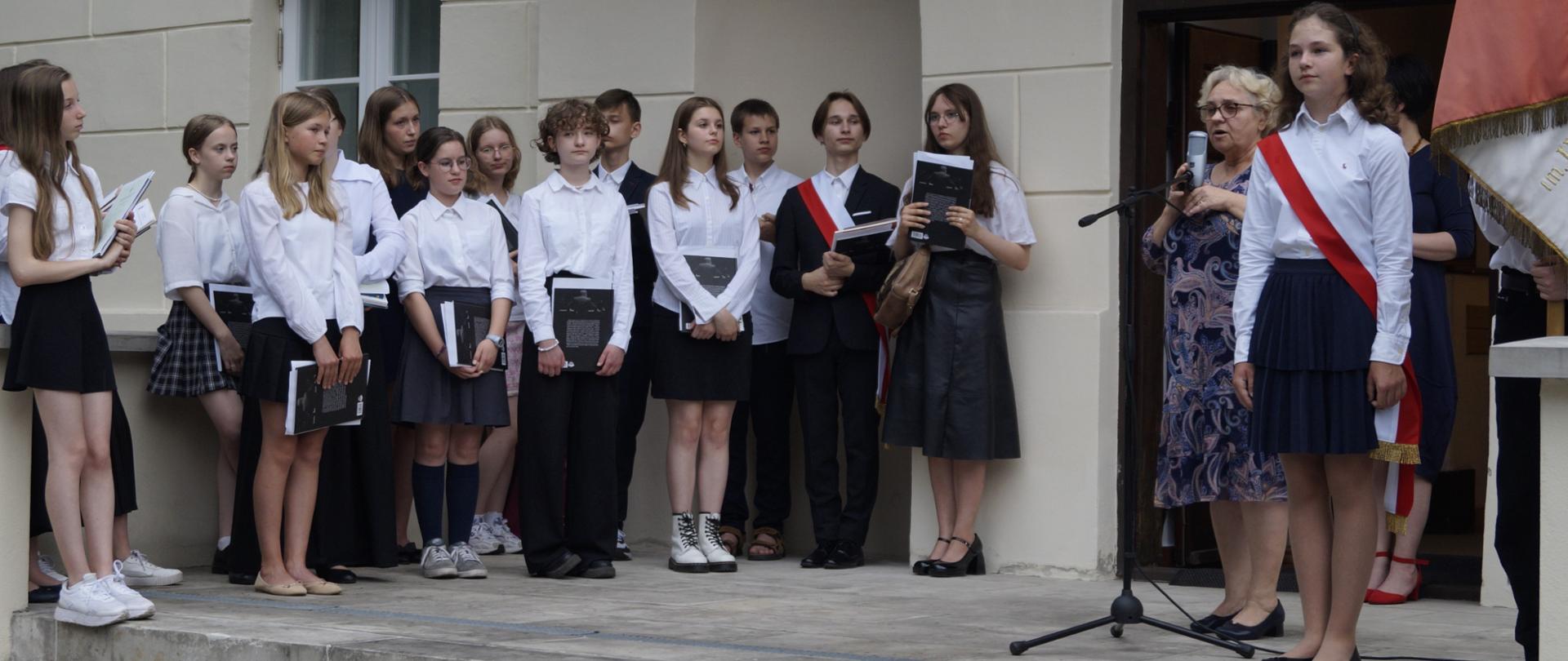 Grupa uczniów wraz z Dyrektorem na uroczystości zakończenia roku szkolnego.